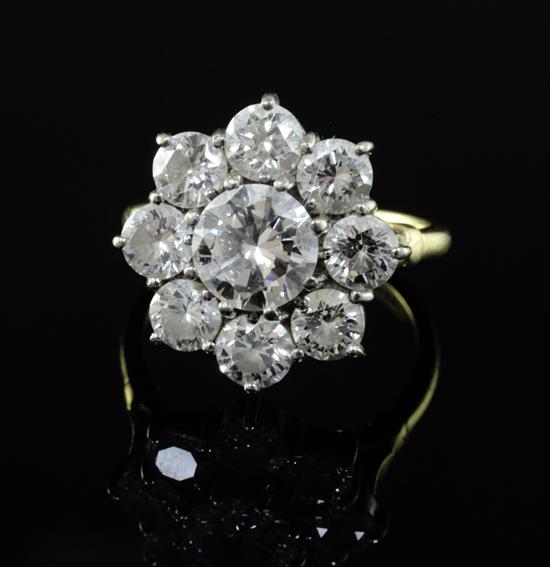 An 18ct gold and nine stone diamond cluster ring, size R.
